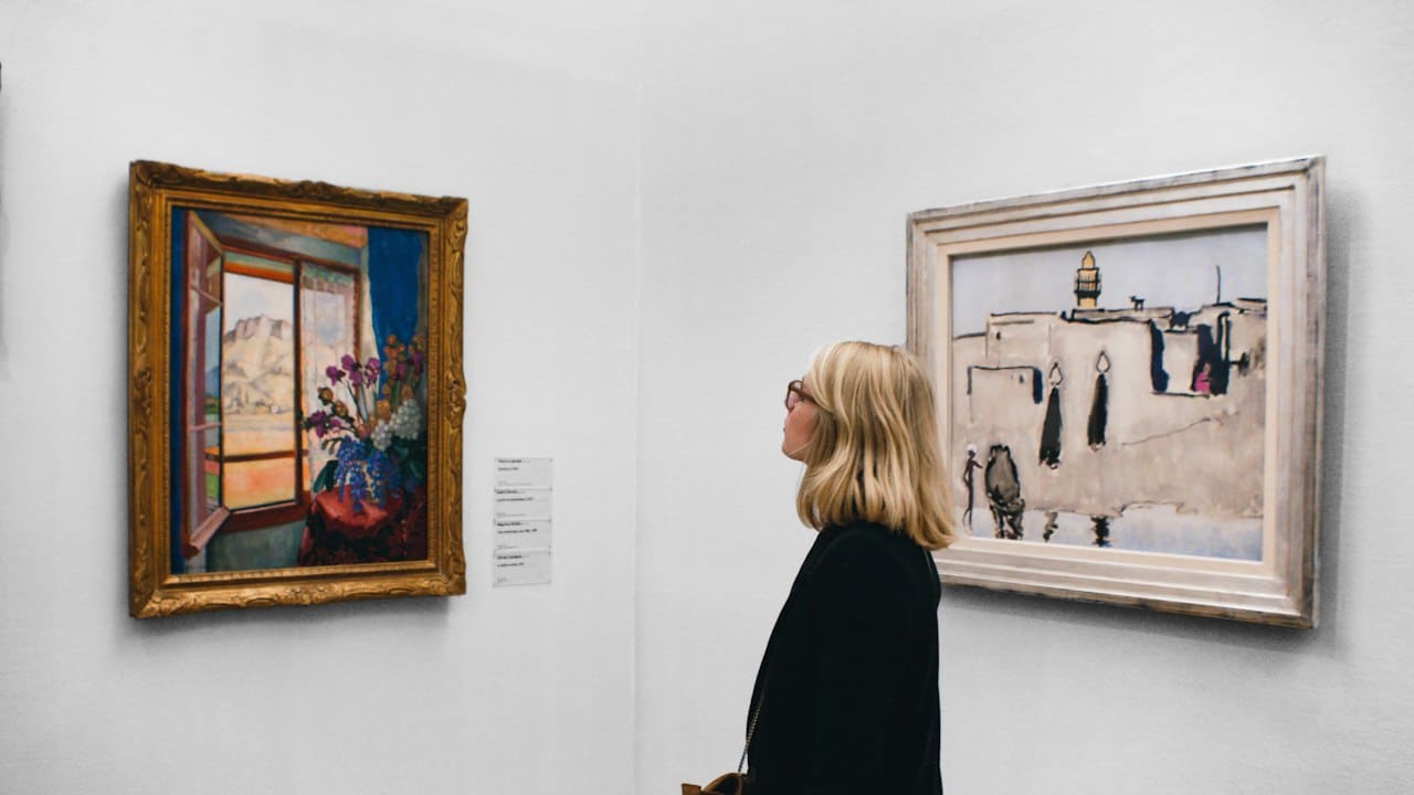 Galeride bir tabloyu inceleyen kadın