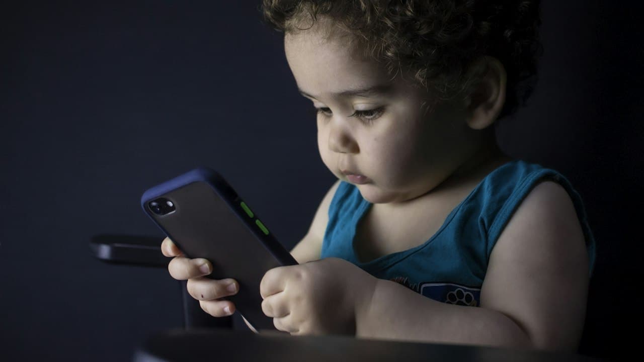 Elinde akıllı telefon tutan erkek çocuk