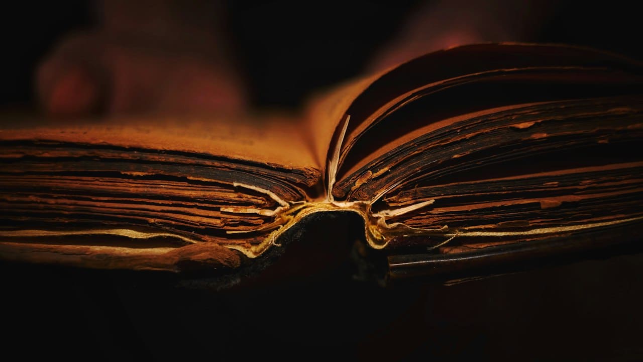 Loş ışıkta açık duran eski bir kitap