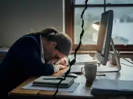 İş dünyasında yeni kavram “Sessiz Çatlama” İş dünyasında sessiz çatlama kavramını simgeleyen, ofis ortamında motivasyon kaybı yaşayan çalışan görseli.