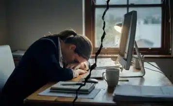 İş dünyasında yeni kavram “Sessiz Çatlama” İş dünyasında sessiz çatlama kavramını simgeleyen, ofis ortamında motivasyon kaybı yaşayan çalışan görseli.