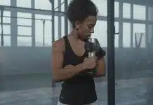 Acemi sporcu sendromu nedir? Kas ağrısına karşı 7 etkili önlem Acemi sporcu sendromu kaynaklı kas ağrısını hafifletmek için spor salonunda masaj tabancası kullanan kadın