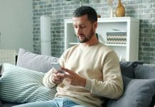 Bel ve boyun sağlığı için riskli şekilde başı eğik telefon kullanan adam
