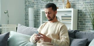 Bel ve boyun sağlığı için riskli şekilde başı eğik telefon kullanan adam
