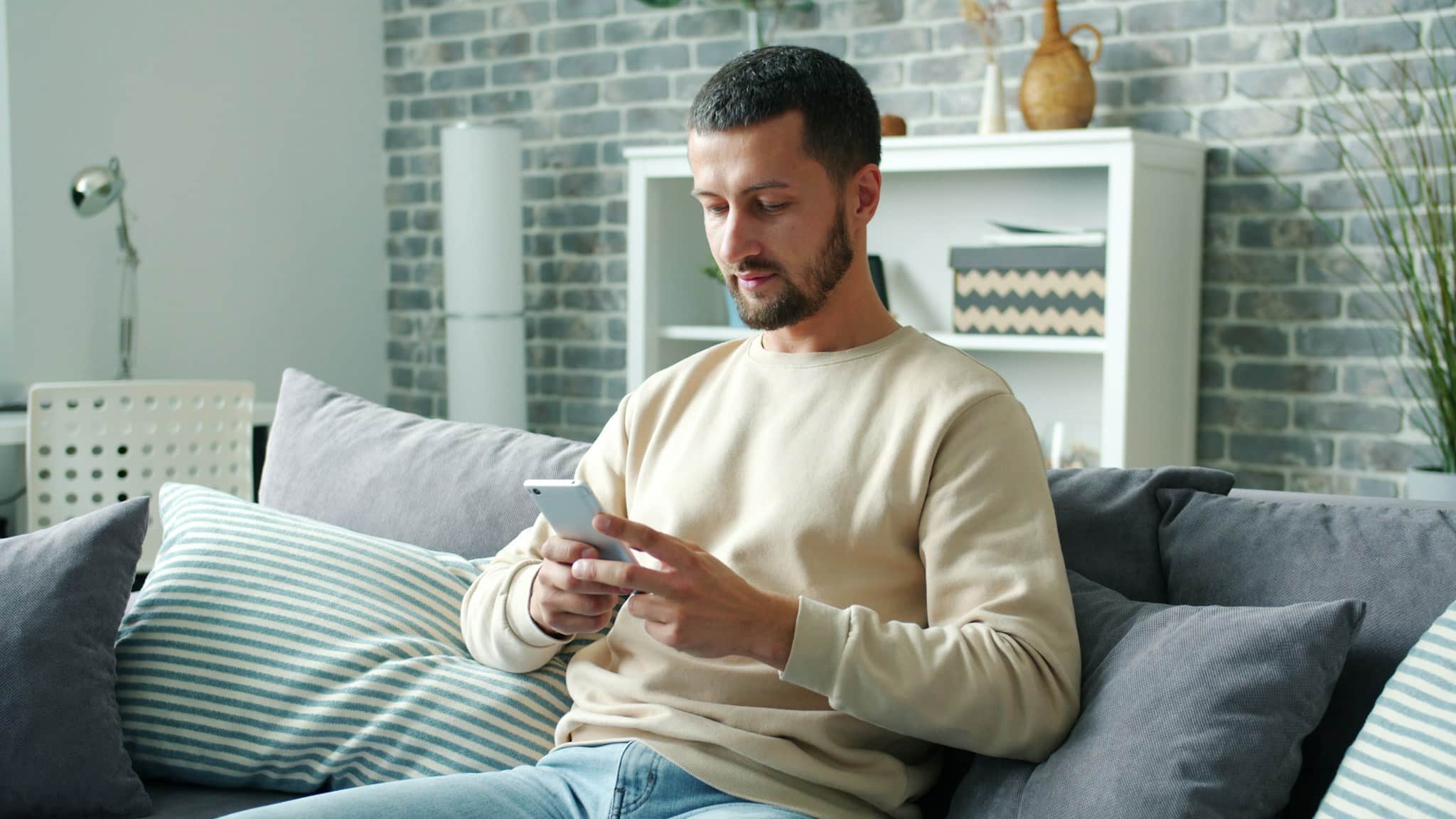 Bel ve boyun sağlığı için riskli şekilde başı eğik telefon kullanan adam