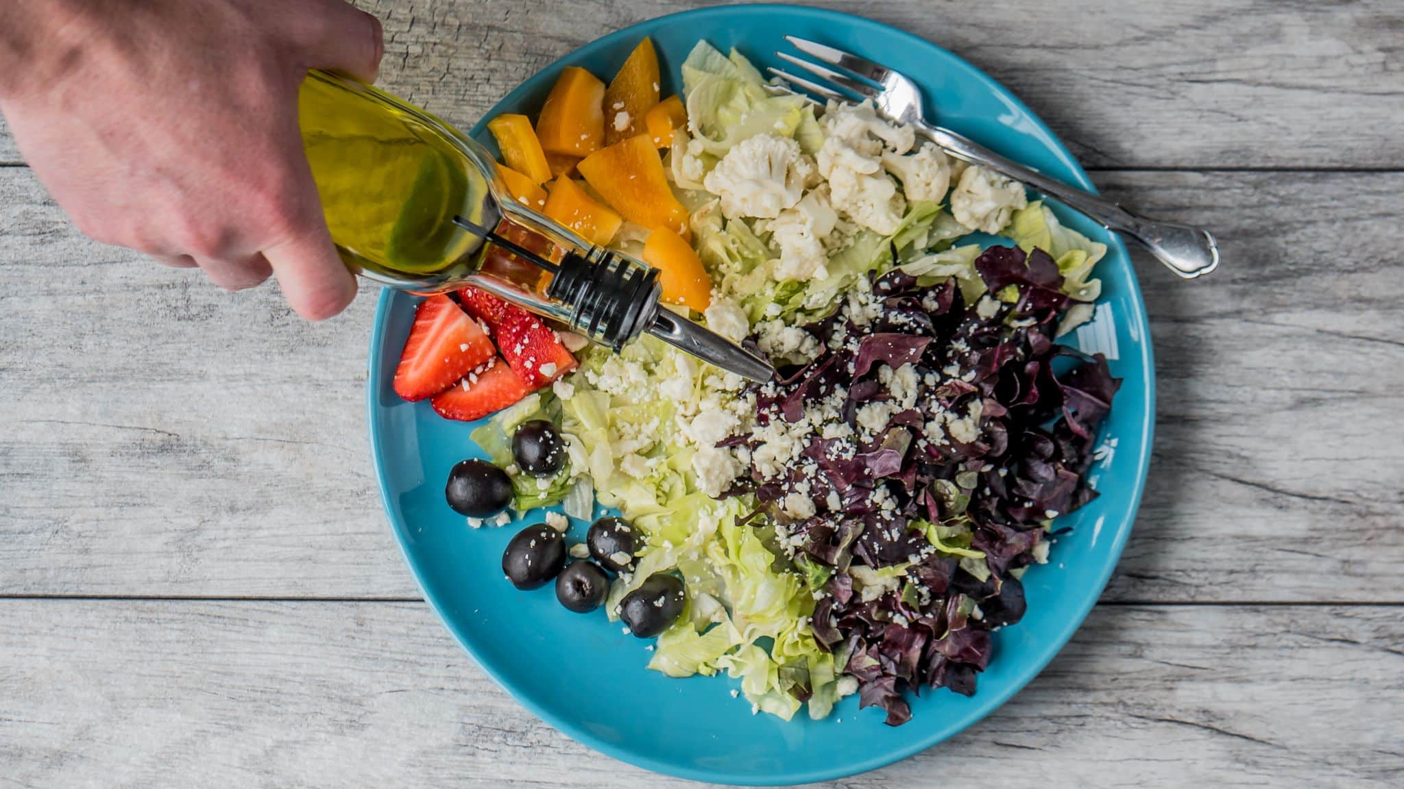 Bitkisel yağlar ve metabolik sağlık ilişkisini anlatan, zeytin ve peynirli sebze salatasının üzerine zeytinyağı dökülen tabak
