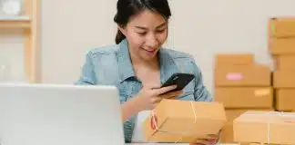 E-ihracat yapmadan önce bu 5 soruya cevap verin E-ihracat siparişlerini dizüstü bilgisayar ve kargo kutuları arasında telefondan kontrol eden bir kadın