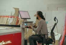 Üretim atölyesinde lazer kesim makinesinin bilgisayarında çalışan genç çalışan; e-ticarette rekabet genç kadrolarla hız kazanıyor