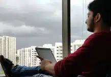 Ev gençliği sorunu: Gençler neden ne eğitimde ne işte? Evde pencere önünde tabletine bakan genç adam; ev gençliği Türkiye'de gençlerin dörtte birini kapsıyor