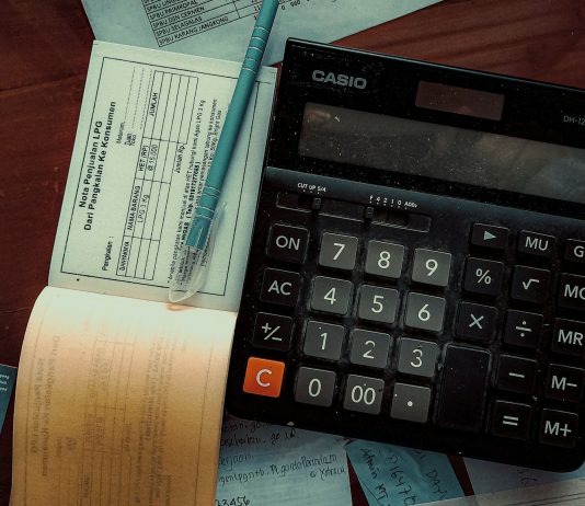 Geç ödemeler ve nakit akışı: Ahşap masa üzerinde hesap makinesi