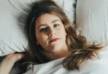 Gece terlemesi hastalık belirtisi olabilir: Hangi durumlarda doktora gidilmeli? Beyaz çarşaflı yatakta uzanan kadın, gece terlemesi ve uyku