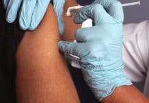 Grip sezonunda influenzadan korunma için hemşirenin bir kişinin koluna yıllık grip aşısı yapması