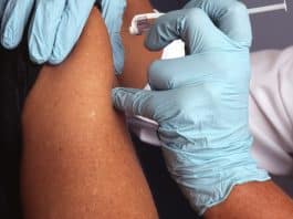 Grip sezonunda influenzadan korunma için hemşirenin bir kişinin koluna yıllık grip aşısı yapması