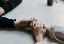 İntihar riski nasıl fark edilir? Uyarı işaretleri nelerdir? Masada el ele tutuşan iki kişi, intihar riski taşıyan kişiye destek olmak
