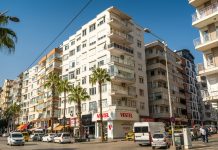 Palmiyeli bir caddede sıralanan apartmanlar; konut yatırımında kira getirisi öne çıkıyor