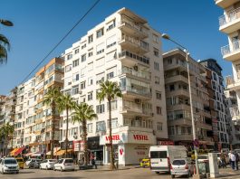 Palmiyeli bir caddede sıralanan apartmanlar; konut yatırımında kira getirisi öne çıkıyor
