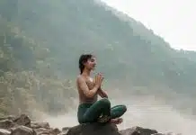 Manevi pratikler zihni şimdiye sabitliyor: Meditasyon, dua ve zikrin psikolojik etkisi Doğada kayanın üzerinde meditasyon yapan kadın; manevi pratikler zihni şimdiye sabitliyor