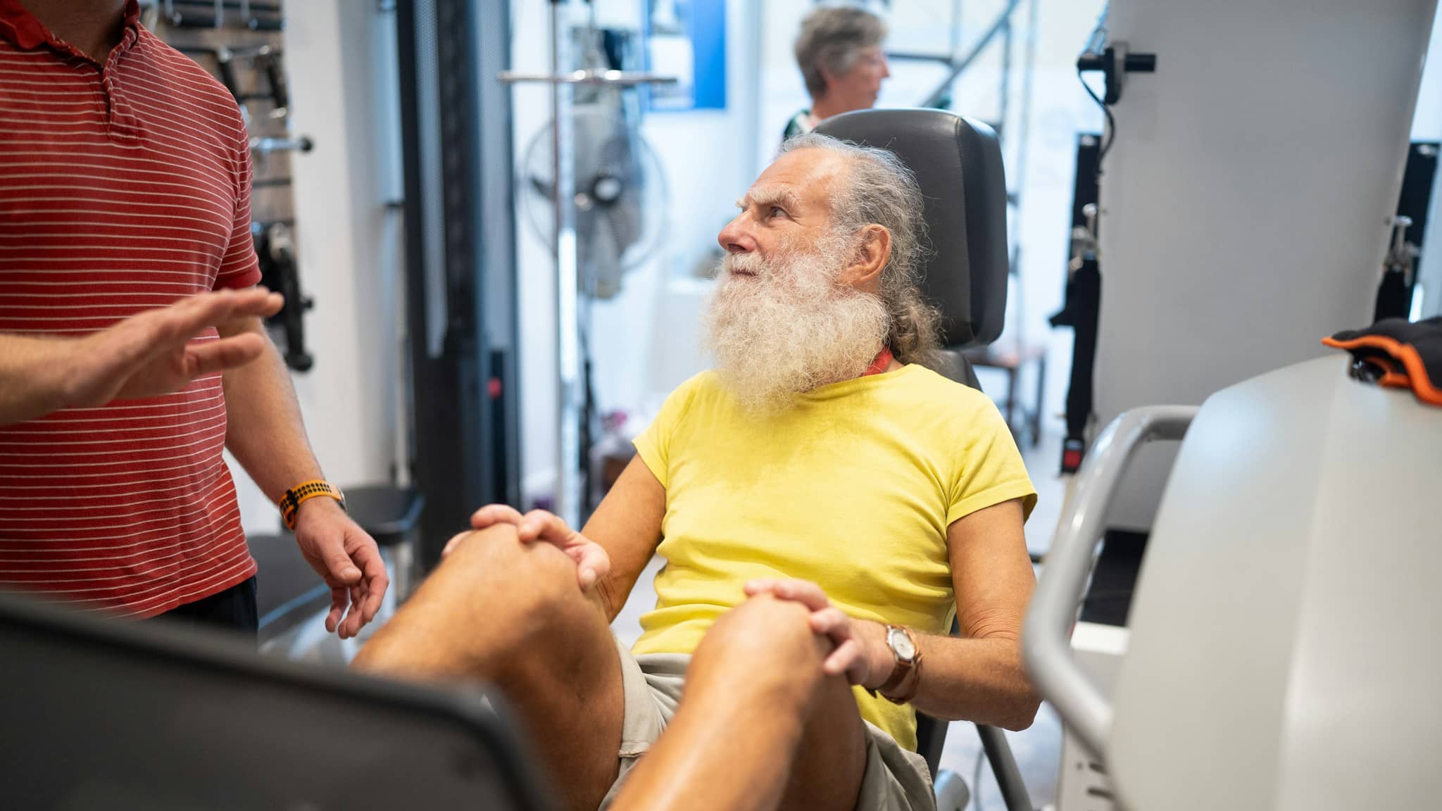 Sarkopeni ve kas kaybına karşı spor salonunda egzersiz yapan beyaz sakallı bir adam