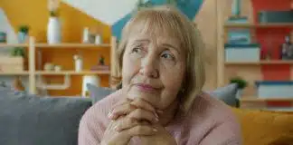 Unutkanlık ve Alzheimer arasındaki fark: Ne zaman endişelenmeli? Unutkanlık ve Alzheimer endişesiyle evde koltukta ellerini kavuşturup düşünen yaşlı bir kadın